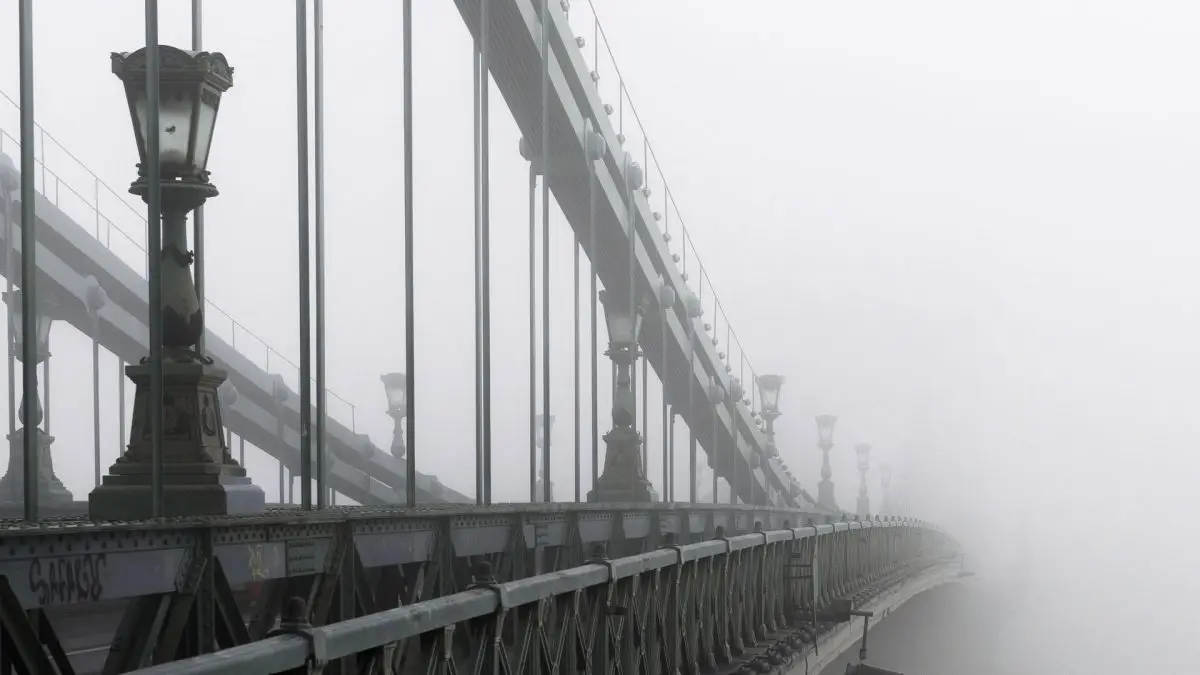 White fog hiding the end of the bridge.